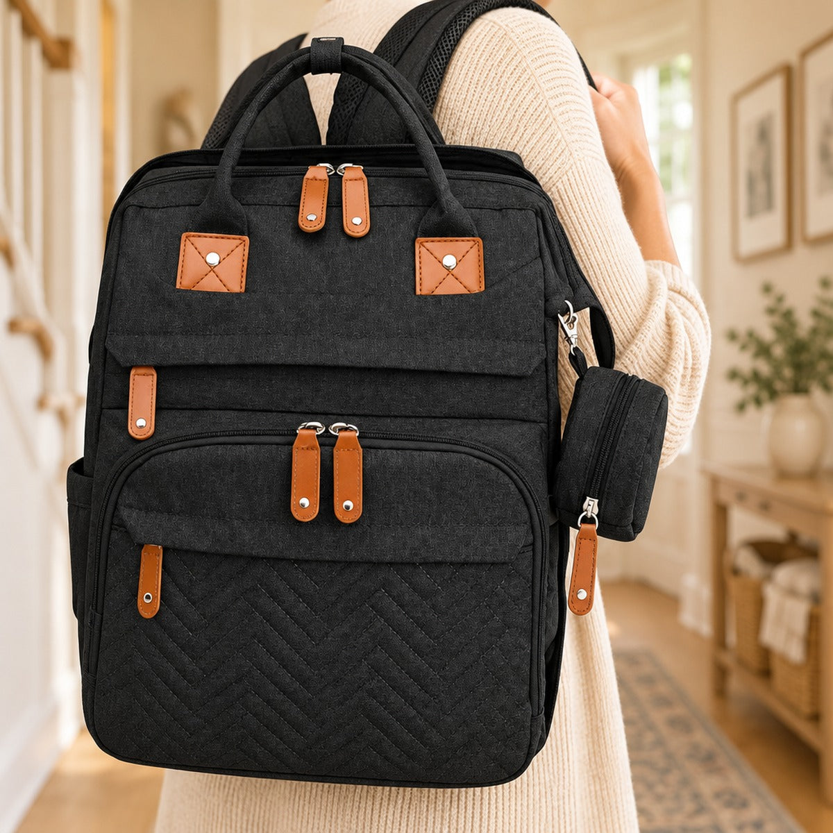 Parent carrying the diaper bag backpack over the shoulder